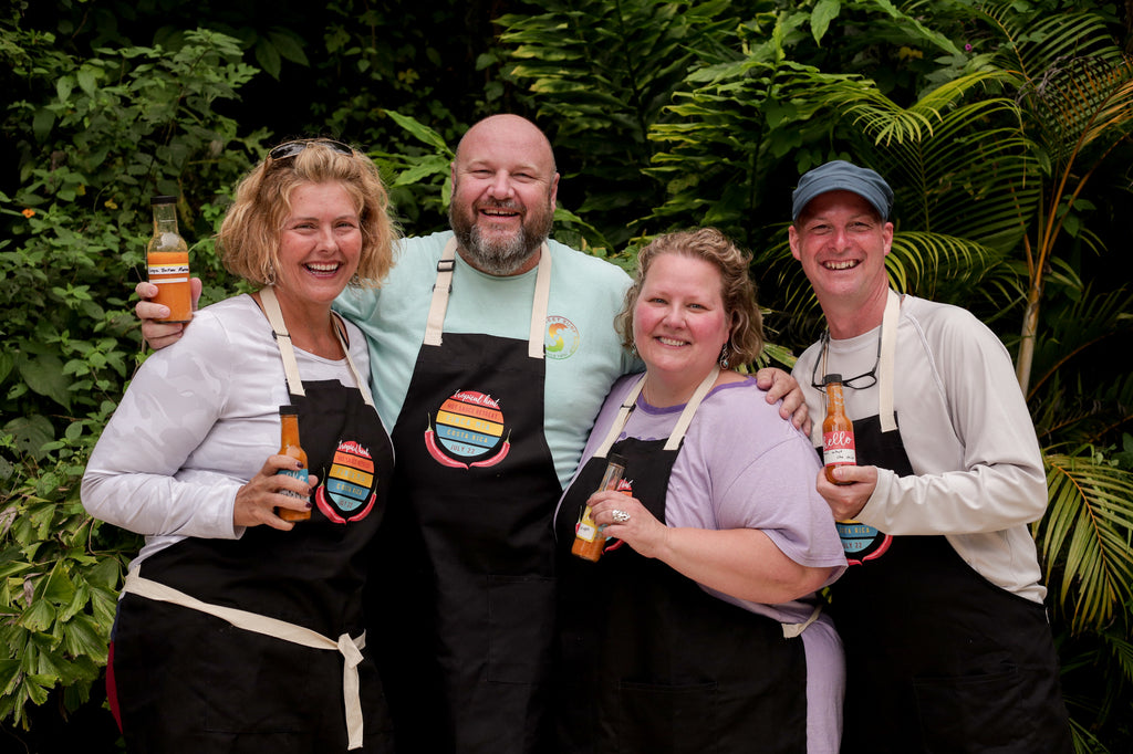 Costa Rica Retreat Guests in Aprons holding hot sauce bottles