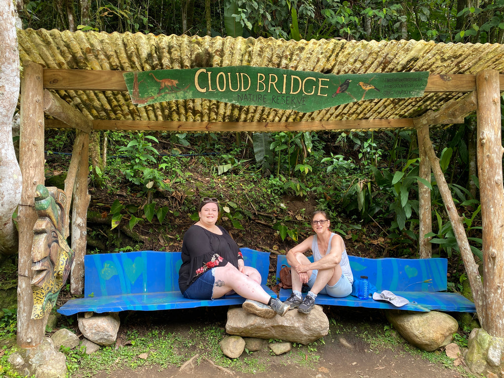 two women relaxing on a bench after a hike at Cloudbridge Nature Reserve